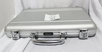 Closed silver aluminum Mezzi briefcase showing front view with latches and handle with brand name