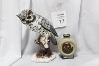 Porcelain owl figurine and ceramic owl vase displayed side by side on white cloth background with lot tag visible