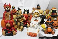 Wide shot showing 19 teddy bear figurines with Halloween and Fall holiday themes in various costumes such as devil, ghost, witch, and pilgrim.
