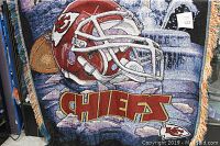 Woven throw blanket with Kansas City Chiefs helmet, logo, and text, showing the full design and fringes.