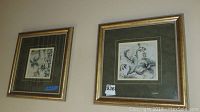 Photo showing two framed floral art prints mounted side by side on a wall.