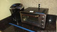Black Keurig coffee maker next to Cuisinart toaster oven on kitchen counter