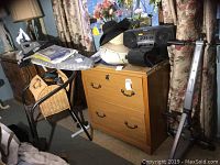 Image showing ironing board with Rowenta iron, ladies hats, Sony boom box, wicker box, and metal wicker chair.