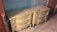 Pair of cream-colored Stanley night stands with two drawers placed side by side showing overall wear and scuff marks