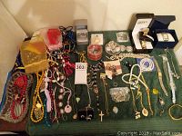 Overview of all costume jewelry and watches on green fabric