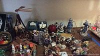 Overview of various small collectibles and statuettes on display including figurines, snow globes, and decorative items.