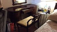 Full view of mahogany vanity and matching chair showing the curved design and overall condition