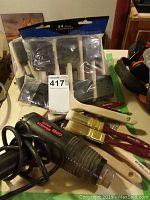 Photo of the Super Stripper 1500 heat gun with several paint brushes and two packages of foam brushes in original packaging.