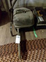 Side view of Poulan PRO gas chainsaw showing black protective guide bar cover and stains on the body and bar.