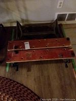Folding work bench and red folding table stacked together showing overall condition and size.