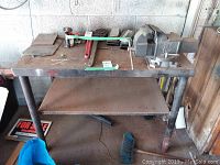 Full view of metal work table with items on top including PowerFist vice.