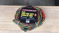 Multi-colored braid tow rope coiled with label on top stating Airhead Deluxe Tube Tow Rope 4 strand