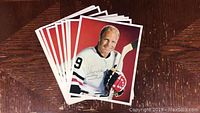 Stack of 9 color photos showing Bobby Hull in hockey jersey number 9 holding a hockey stick and wearing gloves.