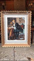 Full view of needlepoint artwork featuring a seated man and the ornate frame.