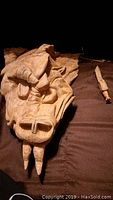 Close-up view of the front face of the hand carved wooden dragon head showing detailed features like horns, eyes, and teeth.