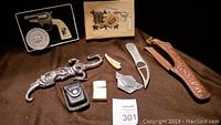 Top-down view of all collector knife lot items arranged on brown fabric.