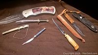 Large folding knife showing entire set with five smaller knives and sheaths