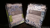 Two Madison Homes reversible quilts, full/queen size, still in original packages showing packaging labels and quilt patterns.