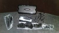 Full lot including ConAir Pro electric hair clippers, storage case, multiple clipper guards, cleaning brushes, and oil on a dark table surface.
