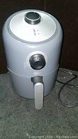 Photo showing full unit with closed basket handle and temperature and timer dials on top.