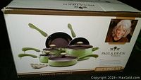Photo of boxed Paula Deen Collection 15 piece porcelain nonstick pot set showing items and green handle design.