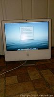 Apple iMac powered on showing desktop screen with setup dialog.
