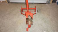 Front view of the Greenlee 1800 mechanical pipe bender showing the orange frame, handle, and pipe bending dies.