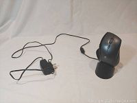 Wireless mouse connected to the charging dock with power adapter visible