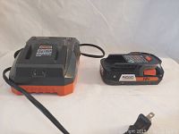 Photo showing Ridgid 18V battery charger and 18V battery side by side on a plain background.