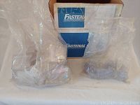 Box with Fastenal branding containing at least two plastic label holders in sealed plastic bags.