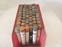 Top view photo showing multiple cylindrical fuses stored upright in a red plastic tray.