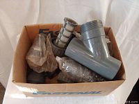 Box containing new Chemline Y strainer parts and filter baskets in plastic packaging.