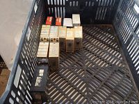 Several assorted rectangular electrical relays with white, beige, and black casings in a plastic tray.