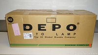 Box of Depo replacement headlight labeled with brand and compliance info.