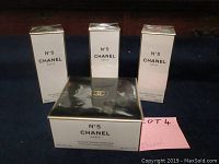 Three tall boxes (two bath gels and one body lotion) and one larger square box (pressed powder) arranged on dark background.