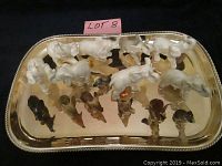 Top-down image of 15 elephant figurines arranged on a gold-tone metal serving tray with a beaded edge.