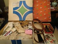 Overview of the lot showing assorted lace, thread, leather belts, and sewing tools inside a box.