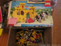 Original box for LEGO set 375 Yellow Castle atop box containing loose pieces