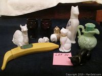 Group photo of Avon bottles and collectible items showing a variety of ceramic and glass animal-shaped bottles, including cats, camel, and decorative pieces.