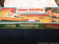 Photo showing the worn vintage box with branding and colorful graphics of the Snap Bowling game and players