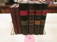 Five vintage books including four volumes/reports from Royal Commission on Technical Education (1913) in black and red bindings, with one smaller brown book, all placed in brass book holder.