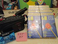 Memorex VHSC video camcorder with multiple control buttons and features, eight sealed Memorex VHS-C tapes, one sealed Sony VHS-C tape shown alongside the camcorder.