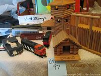 CN model train set with locomotive, freight cars, and wooden fort tower with gate and building