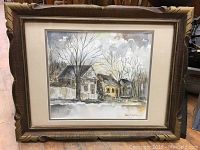 Full view of framed watercolor painting depicting winter house scene, artist signed and dated 1985.