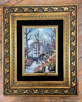 Full view of framed oil painting with intricate gilt frame and black inner matting showing a street or park scene.
