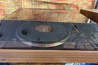 Full view of the Dual 502 belt drive turntable with woodgrain cabinet and transparent dust cover in place showing overall condition and design.