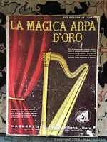 Front of original box with vintage design, showing the harp illustration and Italian text indicating 'La Magica Arpa D'Oro' and manufacturer information.