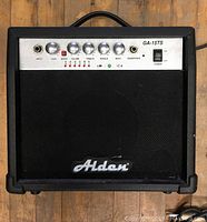 Front view of Alden GA-15TS amplifier showing speaker grille, Alden logo, control knobs, and inputs.