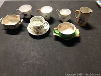 All collectible cups, saucers and creamers arranged front-facing.