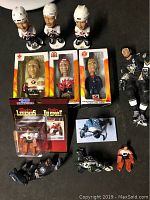 Overview of six hockey bobbleheads and figurines with some in original packaging on a wood surface